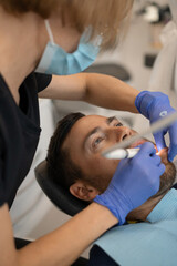 Obraz na płótnie Canvas Young man at the dentist. Dentist woman. Dental office.