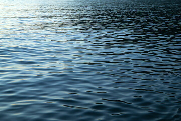 The detail of the calm surface of the sea with the small waves during the evening while sun went already down and the blue shades came. 
