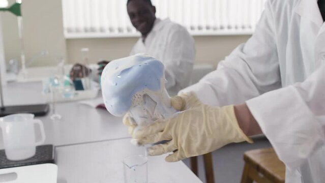 Chemical experiment. Stock footage. Young scientists in the laboratory deduce chemical reactions in special devices.