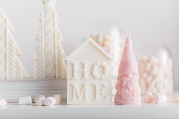 Merry Christmas decoration concept with candles and festive decor, colorful marshmallows, christmas trees on light white background. Cozy home. Space for text.