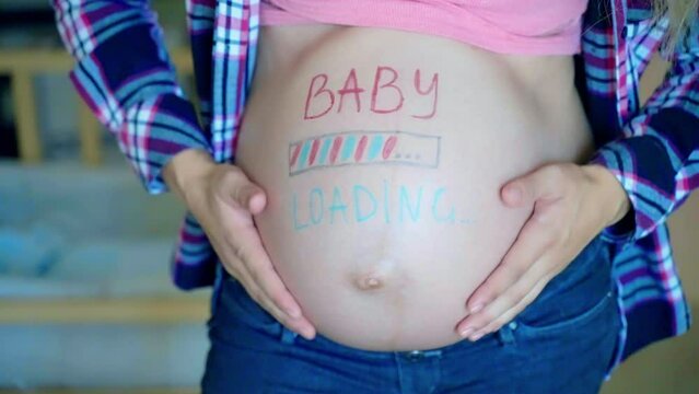 Pink and blue baby loading inscription on woman pregnant belly, mom holding in secret her baby gender, woman caring her adorable round tummy with hands, happy moments of pregnancy, woman ready for her