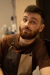 Obraz premium Young handsome barista with red beard, portrait, close-up.