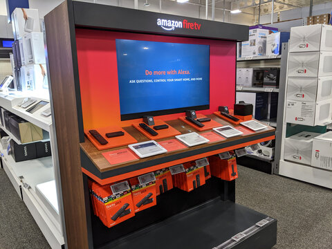 Amazon Fire TV Display inside Best Buy Store featuring Stick and Cube devices with Alexa