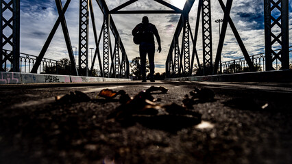 silueta hombre pasando un puente