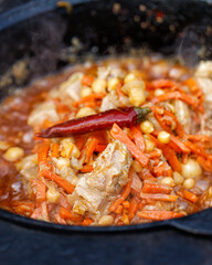 Cooking pilaf in a saucepan or cauldron. Pilaf is prepared on an open fire.