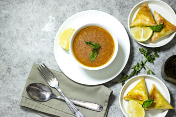 traditional bowl of spiced algerian vegetable soup named (Harira) and meat bourak named bourek and olive oil bottle 