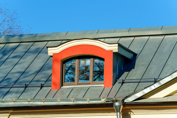 Attic window in modern style on a metal roof