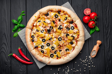 Delicious pizza with chicken meat, pineapple, corn and olives