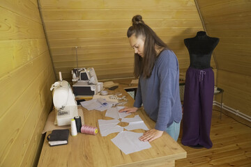 The designer girl lays out a blank for the elements of future designer clothes.