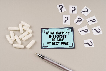 On the table are question marks and a sticker with the inscription - What happens if i forget to take my next dose - obrazy, fototapety, plakaty
