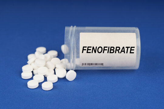 On a blue surface are pills and a dusty jar with the inscription - Fenofibrate