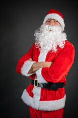 Portrait von einem verkleideten Weihnachtsmann mit Geschenk, isoliert auf grauen Hintergrund im...