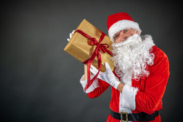 
Portrait von einem verkleideten Weihnachtsmann der auf einen Platzhalter zeigt und isoliert vor grauen Hintergrund ist 