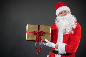
Portrait von einem verkleideten Weihnachtsmann der auf einen Platzhalter zeigt und isoliert vor grauen Hintergrund ist 