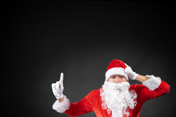 
Portrait vom Weihnachtsmann der auf einen Platzhalter zeigt und isoliert vor grauen Hintergrund...