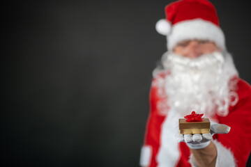 
Portrait von einem verkleideten Weihnachtsmann der auf einen Platzhalter zeigt und isoliert vor grauen Hintergrund ist 