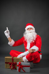 
Portrait vom Weihnachtsmann der auf einen Platzhalter zeigt und isoliert vor grauen Hintergrund ist 