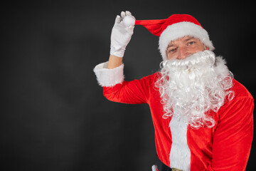 
Portrait vom Weihnachtsmann der auf einen Platzhalter zeigt und isoliert vor grauen Hintergrund ist 