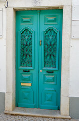 Obraz na płótnie Canvas Vintage entrance door of vibrant blue colour and metallic ornamental details in Algarve, Portugal