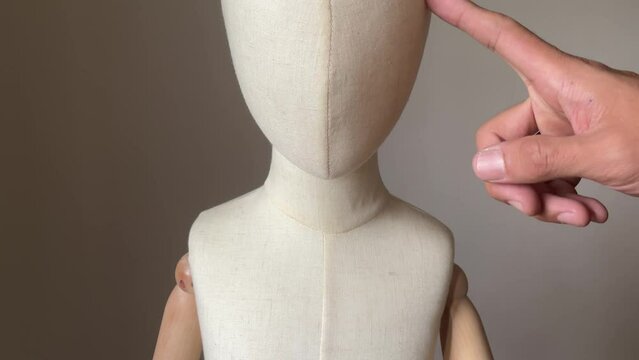 Creepy male finger touching child mannequin face. Child abuse concept. Young children victim of domestic violence.