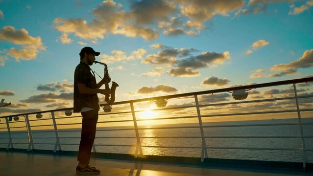 Saxophonist at sunset. Silhouette on background of seascape