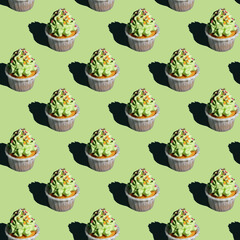 Creative seamless pattern made of Christmas baubles with sprinkles and ribbons on a pastel pink background. Minimal winter Holidays composition.