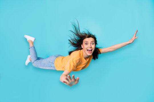 Full length photo of astonished girl impressed open new skills can fly hand wings isolated on blue color background