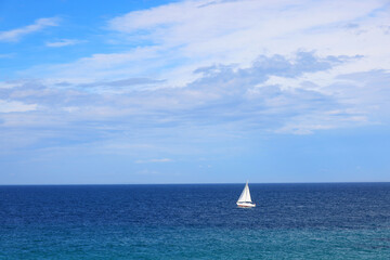 Fototapeta premium Lonely Sailing boat on blue open sea in Apulia, Italy. 