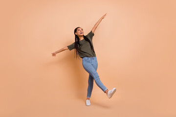 Fototapeta na wymiar Full body photo of overjoyed cheerful person dancing raise hands toothy smile isolated on beige color background