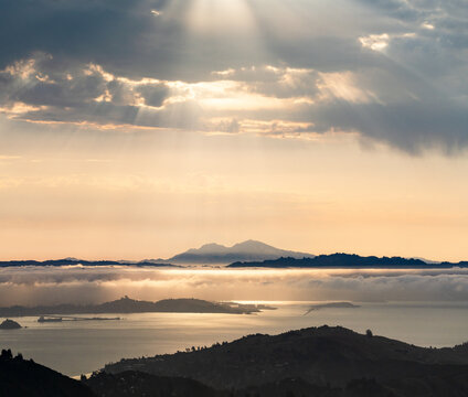 Morning light filters through clouds, shining down on Mount Diablo and the East Bay, viewed from Mt. Tamalpais.