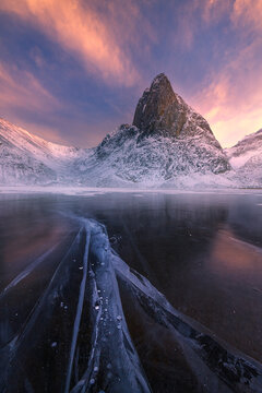 frozen lake in front of mountain at sunset