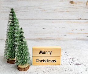 Merry Christmas Greeting Card with  Green Pine Trees on White Wooden Background 