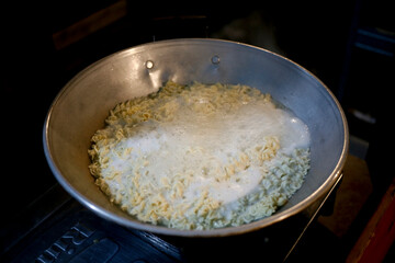 frying pan of boiling water with noodles on the cooker. cooking noodle at night. 