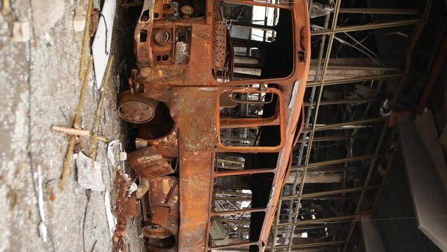 Metal bus frame. The rusty old body of the bus was turned into scrap metal by fire as a result of shelling by rockets and bombs. War brings destruction and death. War in Ukraine. Russian aggression.