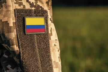 Close up millitary woman or man shoulder arm sleeve with Colombia flag patch. Colombia troops army, soldier camouflage uniform. Armed Forces, empty copy space for text
