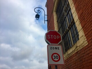 Panneau Stop et panneau d'entrée dans une zone limitée à 30 km/h