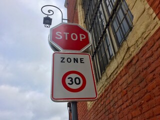 Panneau Stop et panneau d'entrée dans une zone limitée à 30 km/h