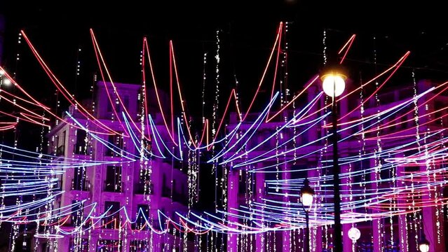 Madrid, Spain, 30 November 2022. New year 2023 city decorations. Huge beautiful illumination, purple, pink LED garland lights. Shiny, sparkling, ornately decorated for Christmas megapolis wallpaper.