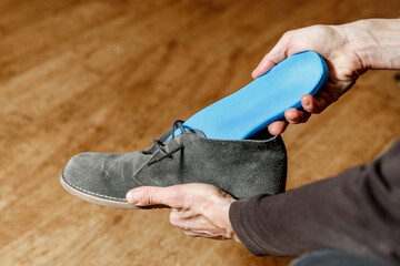 Man putting new custom insole in a shoe.