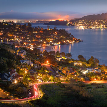 Fog flows through the Golden Gate at sunset, seen from Tiburon, California