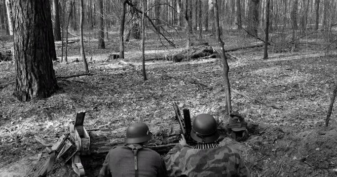 German Wehrmacht Infantry Soldier In World War II prepare for Shooting machine gun from Forest entrenchment. reload weapon. Black And White Colors