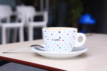 cup of coffee with cream and coffee beans close up photo