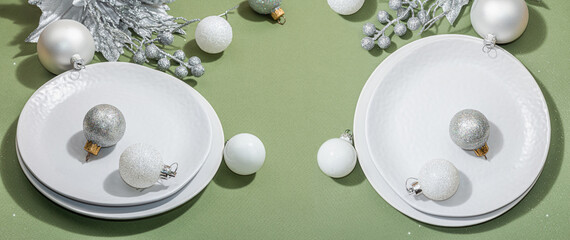 Christmas table setting with ceramic plates, traditional decor on Savannah Green color background