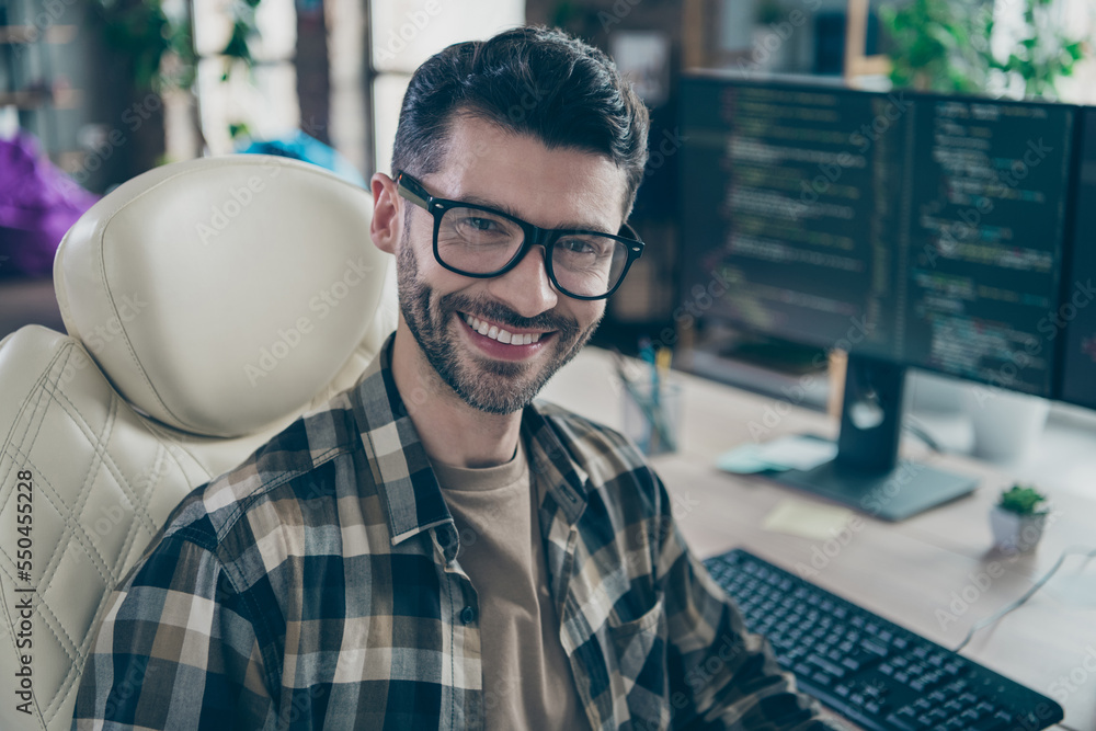 Poster portrait of cheerful hacker guy sit leather chair toothy smile operate pc server open space workstat