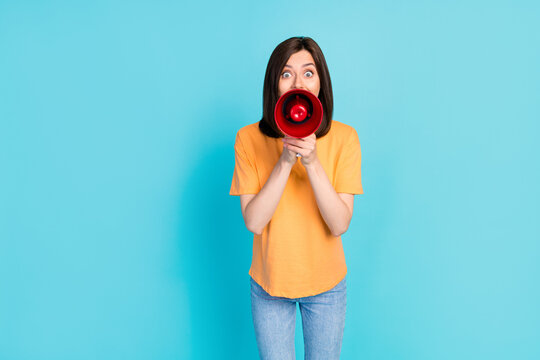Photo of astonished impressed positive girl wear yellow t-shirt hold loudspeaker scream information isolated on turquoise color background