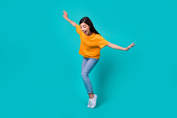 Full body photo of funky brunette lady dance look down wear t-shirt jeans boots isolated on teal...