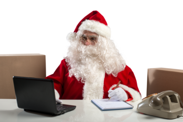 santa claus works in office with laptop and phone