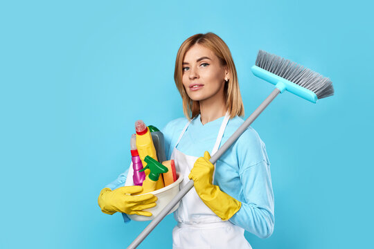 Woman In Gloves Holding Bucket Of Detergents And Broom