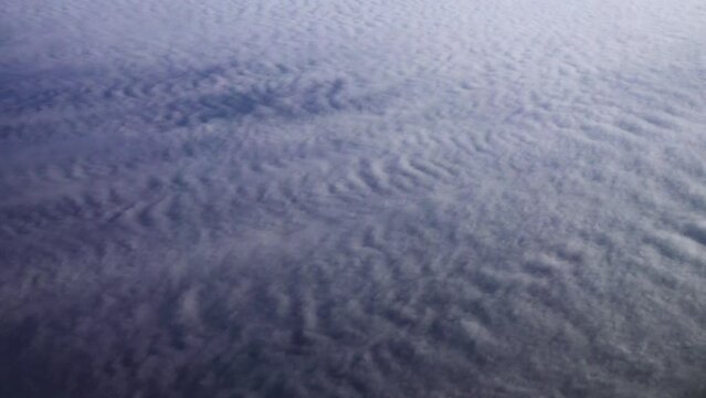 Cirrocumulus, granular cloudlets. Fleece clouds under the wing of an airplane. The flight takes place at an altitude of 11,000 meters