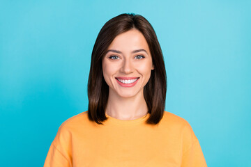 Photo of pretty nice gorgeous girl with straight hairdo wear yellow t-shirt toothy smiling dental ad isolated on blue color background